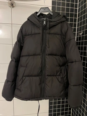 Svart pufferjacka från H&M - Säljer min svarta vintage från H&M, den är använd 1 säsong men kommer tyvärr inte till användning längre. Storlek Xs men den är syror i storleken så uppskattar den till Xs/M beroende på önskad passform! Behöver plats i garderoben så pris kan diskuteras vid snabb affär🥰 Finns det frågor är det bara att skiva🤗🤗