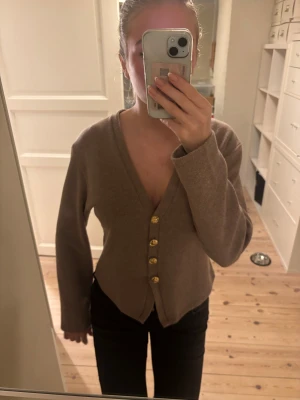 Brun stickad tröja med guldknappar - Superfin brun mjuk stickad kofta ifrån Zara och snygga guldiga knappar framtill. Modellen har långa ärmar och tröjan är i 50% bomull! Mjuk och skön, perfekt nu till vintern.💕