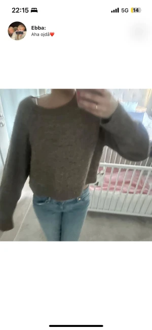 Brun stickad croppad tröja - Mysig brun stickad tröja med croppad passform och långa ärmar. Tröjan har en enkel design med rund hals och ribbade muddar vid ärmslut och nederkant. Perfekt att matcha med jeans för en chill look.