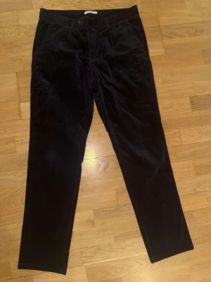 John Henric manchesterbyxor - Snygga mörkblåa manchesterbyxor i storlek W50 (M/L) med klassisk rak passform och diskreta fickor fram. Byxorna har knapp och dragkedja i midjan. Materialet är en mix av bomull och polyester med lite elastan för extra komfort. Perfekta för dig som gillar lite mer proper stil. Nypris ligger på 999 kr. Dessa är använda vid 3 tillfällen sen bara legat i garderoben. Finns inget fel på dem alls!