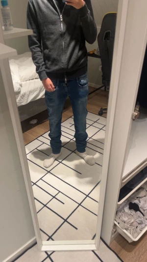 Replay blå jeans straight fit - Säljer ett par snygga blå jeans från Replay med klassisk straight fit. Jeansen har ljusare tvättade partier, fem fickor och coola detaljer på bakfickorna med gul söm. Perfekt passform och skön stretch i materialet.