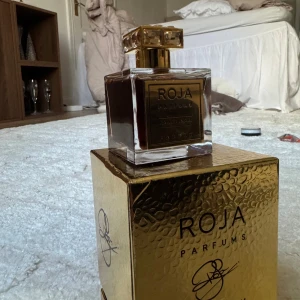 Roja Amber Aoud Parfum - Föreslå ett pris.                                                            NYPRIS 9249kr. Lyxig och exklusiv parfym från Roja Parfums. Amber Aoud Parfum kommer i en elegant förpackning med gulddetaljer, perfekt för dig som vill sticka ut och visa din unika stil.      TOP NOTES: Lemon, Bergamot, Lime. HEART NOTES: Rose de Mai, Jasmin de Grasse, Ylang Ylang, Fig. BASE NOTES: Cinnamon, Saffron, Patchouli, Oakmoss, Sandalwood, Aoud, Benzoin, Orris, Birch, Ambergris, Musk