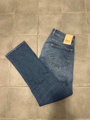 Replay Hyperflex Jeans - Snygga blå replay hyperflex jeans i modellen grover. Storlek W31 L30. Har ett litet hål i skrevet (se bilden) som jag inte har orkat laga men tror inte det hade vart särskilt omständigt att sy ihop. Priset är ej hugget i sten, hör av dig vid funderingar🙌🤩