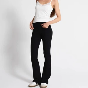 Svarta bootcut yogapants  - Svarta mjukisbyxor med bootcut-snitt och låg midja. Byxorna har en skön och stretchig passform som sitter snyggt över höfterna och låren, och släpper ut vid bensluten. Perfekta för en chill och avslappnad stil. 