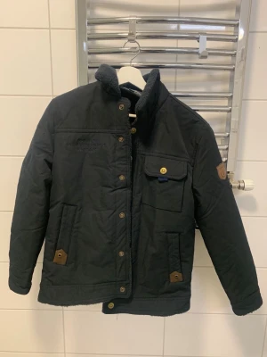 Mörkblå fältjacka med bruna detaljer - Den är jätte bra skick, bara använd när jag har testat jackan. Det är storlek L men den är ganska liten i storleken så den känns som en M och S. Från new fashion