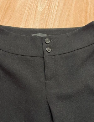 Nya svarta kostymbyxor XS - Svarta kostymbyxor med två knappar och dragkedja fram. Raka/lite bootcut, ALDRIG ANVÄNDA! Super lågmidjade❤️❤️