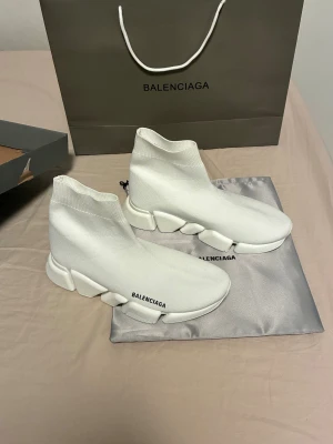 Vita Balenciaga Speed sneakers - Säljer ett par vita Balenciaga Speed runners. Använda endast 1-2 gånger förutom det är dem som nya inte en ända skråma på dem. Storlek 43 men passar även 42 och 41 om man lägger in en sula. Samma går för storlek 44 funkar också om man gillar att dem sitter lite tajtare 