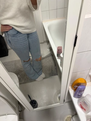 Bootcut jeans med slitna knän från Nelly - Bootcut jeans från Nelly i ljusblå tvätt med låg midja och slitna hål vid knäna. Klassisk femficksmodell med dragkedja och knapp framtill. Jeansen har breda ben och är tillverkade i bomullsmaterial för en skön känsla.