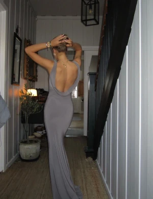 Taupe långklänning Designbysi med öppen rygg - Supersnygg taupefärgad långklänning med öppen rygg från designbysi. Aldrig använd och har prislappen kvar. Superfin till någon fest eller bal. Nypris 575kr