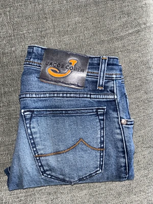 Jacob cohën jeans - Tja säljer dessa Jacob cohën jeans med klassisk femficksdesign och kontrastsömmar. Modell 688. Jeansen har en rak passform.  Strl: längden från midjan till längst ner på benen är 93cm, strl på midjan 38cm. Nypriset på dessa är 3499kr. Perfekta för dig som gillar en avslappnad men ändå stilren look. Hör av er vid intresse/ frågor!