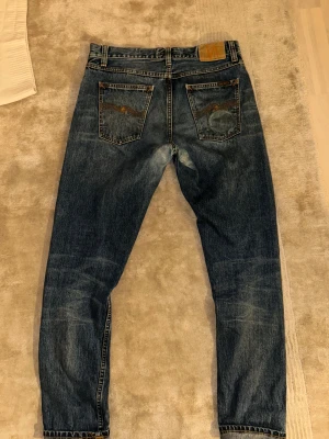 Selvedge Nudie Jeans Steady Eddie II - Säljer ett par Nudie Jeans Steady Eddie II Stormy Selvage i klassisk blå tvätt. Jeansen har raka ben. Storlek 32/32 och skit bra skick. Vid frågor är det bara att skriva!😃
