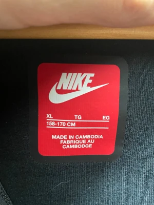 Svart Nike fleecejacka XL - Säljer en svart fleecejacka från Nike i storlek XL. Jackan har dragkedja framtill, hög krage och diskret Nike-logga på bröstet. Perfekt för dig som vill ha en enkel och clean look med sportig vibe.