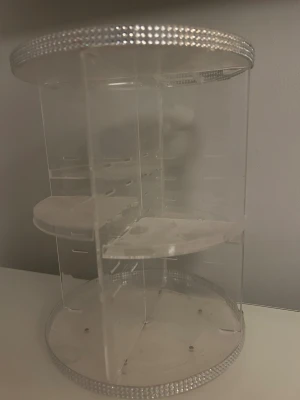 Roterande sminkförvaring med strass - Snygg och praktisk roterande sminkförvaring i transparent akryl med glittriga strassdetaljer längs kanterna. Perfekt för att organisera sminkborstar, läppstift och andra sminkprodukter. Flera hyllplan och fack för enkel översikt.💓
