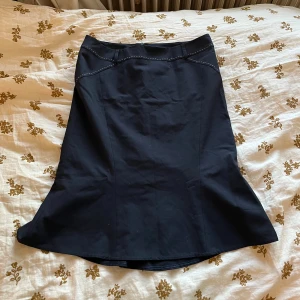 Utsvängd marinblå midikjol - Längd framtill är 61 och baktill 66 cm. Midjan är 42 cm. Jag använde en klädrulle på den efter att jag tagit bilderna, så majoriteten av dammet som syns på bilderna bör vara borta.