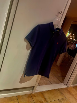 Marinblå pikétröja Polo Ralph Lauren - Säljer en marinblå pikétröja från Polo Ralph Lauren i slim fit-modell.Andvänd en få tal gånger. Kvaliten är enormt bra på pikén. Kan gå ner i pris till ett bra pris.