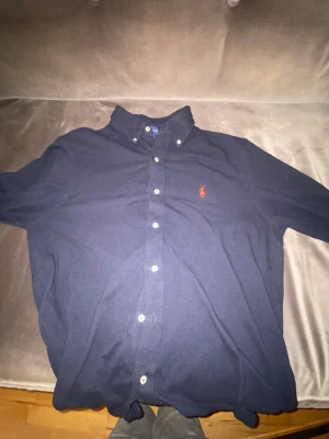 Mörkblå skjorta från Ralph Lauren M - Snygg mörkblå skjorta från Ralph Lauren i featherweight mesh. Klassisk button-down krage,  perfekt för en clean och stilren look. Har knappast använt den