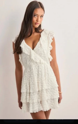 Vit spetsklänning med volanger - Supersöt vit kortklänning som är perfekt till studenten. Klänningen har flera lager volanger och är täckt av spets med blommigt mönster. Jag har vanligtvis S/SX men upplevde att de mindre storlekarna var för korta därav passade M bättre på mig som är 169 cm lång och eftersom det är ganska stretchigt typ så blev den inte för stor.