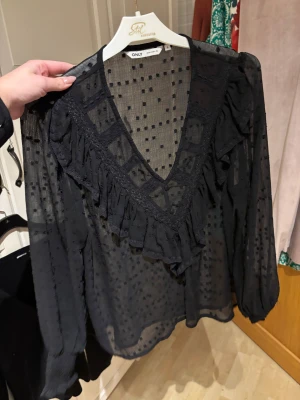 Svart blus från ONLY - Säljer en svart transparent blus från ONLY i storlek S. Blusen har ett prickigt mönster, djup v-ringning med volangdetaljer och långa puffärmar med smock vid ärmslut. Perfekt för dig som gillar trendiga och feminina detaljer. Passar både till vardag och fest ❤️