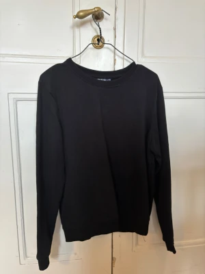 Svart långärmad tjocktröja  - En stilren svart långärmad tröja från OTP i storlek M (sitter som en S). Tröjan har rund halsringning och är tillverkad i mjuk bomull som känns skön mot huden. Passformen är normal och designen är enkel utan mönster eller detaljer, perfekt för en clean look.  💞 Köpt på gekås, knappt använd, inte de mjuka luddiga materialet inuti!
