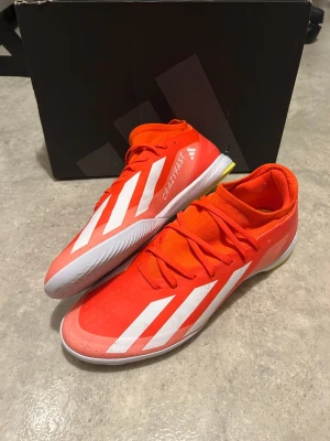 Adidas Crazyfast fotbollsskor röd - Säljer ett par Adidas Crazyfast fotbollsskor i en riktigt snygg röd färg med vita detaljer och gula partier på sulan. Skorna har snörning, låg profil och är tillverkade i syntetmaterial. Perfekta för dig som vill sticka ut på planen. Skorna är endast använda en gång och är i utmärkt skick. Originalpris 1000kr (80GBP)