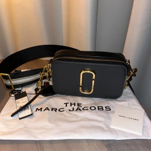Marc Jacobs väska  - I väldigt fint skick, de enda defekterna är på märket som är lite repat men det är ingenting man tänker på. Dustbag och äkthetsintyg följer med. Den är i färgen shadow multi och passar till allt!! Köpt för 3.300kr. Priset kan diskuteras🥰