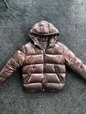 Zara vinterjacka - Säljer en vinröd pufferjacka från Zara i storlek M. Jackan har en stor, mysig huva och breda, quiltade sektioner. Materialet är glansigt och syntetiskt, med en rejäl dragkedja framtill. Perfekt för kalla dagar när du vill ha både stil och värme. Skick 8/10 är använd, storlek M. Pris går att diskutera✅