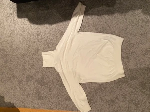 Vit polotröja från Zara - Snygg vit polotröja från Zara i storlek M men passar även mindre då jag vanligtvis har s/xs. Tröjan har lång ärm och hög polokrage, perfekt för lager på lager. Materialet är mjukt och stickat, vilket gör den skön att bära under kyliga dagar. Enkel och clean design som funkar till många olika stilar.