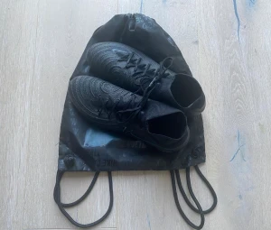 Nike Fotbollsskor - Säljer mina Nike Phantom Luna ll Elite AG-pro i färgen shadow - svart/grön. Storlek 41. Endast använda vid några enstaka tränings tillfällen tills jag insåg att det inte var rätt storlek.   Designade för att användas på konstgräs men det går att använda skorna på vanligt gräs.   Köpte skorna för 2619kr, säljer de för 1200kr 