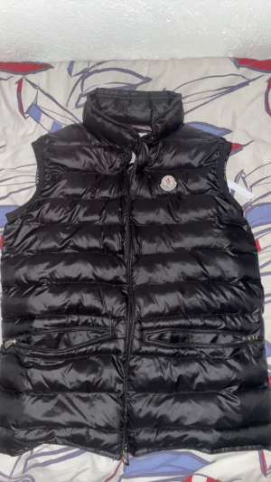 Moncler väst - En väst från brand Moncler som är i bra skicka som har massa fina detaljer och som är äkta och är bara använd 4 gånger. Priset ligger just nu på 1200 kr men priset kan diskuteras genom dm!!