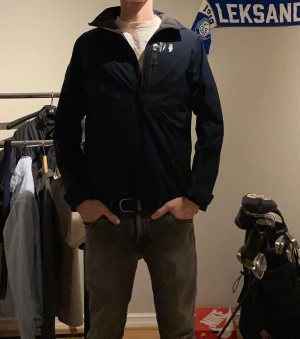 Helly Hansen jacka  - Mörkblå Helly Hansen vindjacka som är lättfodrad, jackan är i jättebra skick och är knappt använd, funkar bra att ha väst under i kallare väder! Skriv gärna vid funderingar! Modellen är 183 cm