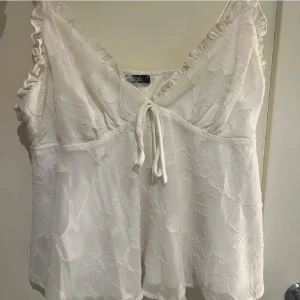 Vit topp - Supersöt blommig topp/linne från gina i 34💕Lite skada men borde gå att fixa till/klippa bort☺️😆