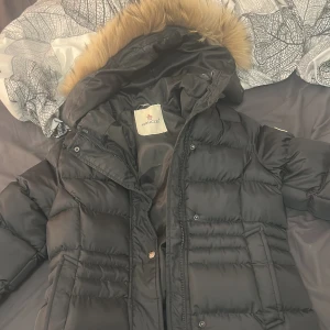 Svart Moncler pufferjacka med päls - säljer en moncler jacka eftersom den är liten pälsen är utbytt mot äkta päls den är helt oanvänd. den är från farfech och den är godkänd, det går och ha hoodie under jackan och det blir absolut inte tajt. priset kan diskuteras
