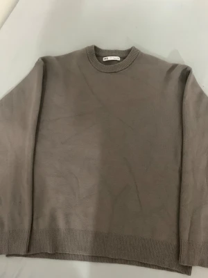 Beige stickad tröja från Zara - Snygg beige stickad tröja från Zara med rund hals och ribbade muddar vid hals, ärmslut och nederkant. Enkel och stilren design som funkar till många olika looks. Perfekt för dig som gillar neutrala färger och mjuka material.storlek S. köpte den förra veckan men den var för liten. Kom med prisförslag, kontakta om du är intresserad.