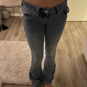 Super lågmidjade true religion jeans! - Säljer ett par super lågmidjade jeans från true religion. Använts mycket, man kan se defekter. Säljer för de inte används längre. Defekterna syns dock inte när man har på sig jeansen. 