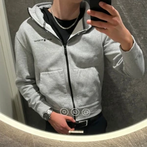 Hoodie från Sail Racing  - Säljer denna gråa zip hoodien från Sail Racing. Säljer den då den blivit för liten. Storlek: Barn 176, sitter som S. Cond: 7:10, inga defekter bara tecken på användning. Nypris: 999kr. Säljer den för 499kr och priset kan diskuteras! 