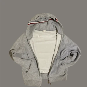 Grå Moncler hoodie med huva - Grå Moncler-kofta med huva. Snygg och bekväm modell. Litet slitage vid ena handleden, NFC finns även i Moncler-patchen