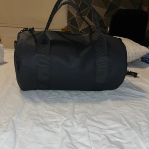 Svart gymväska - Snygg gymväska aldrig använd då den va inte rätt färg för mig. Kan tänka mig att förhandla om priset är rimligt. Väskan är 32.5x20x20 