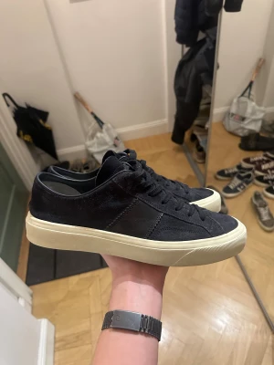Svarta Tom Ford sneakers i mocka - Ett par mörk blåa Tom Ford Cambridge sneakers i väldigt bra skick, använt ett fåtal gånger. Brukar vara en ganska så sällsynt sko, framför allt i storlek 42-45.