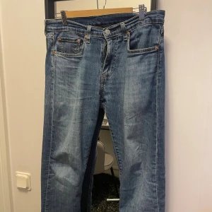 Levi's 502 blå jeans straight fit - Säljer ett par Levi's 502 jeans i klassisk blå tvätt med straight fit. Jeansen har fem fickor, knapp och dragkedja fram samt Levi's ikoniska läderpatch och röd etikett bak. Perfekt för dig som gillar en tidlös och chill look. KAN GÅ NER I PRIS. 