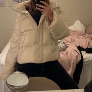 pufferjacka från Marc O'Polo - Säljer en beige pufferjacka från Marc O'Polo med hög krage och dragkedja framtill. Jackan har en quiltad design. Kan ha lite missfärgningar i kragen från smink. Bra pris! 