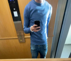 Blå merino ull tröja från Lawrence Grey - Snygg blå stickad tröja från Lawrence Grey med rund hals och långa ärmar. Enkel och stilren design utan mönster, perfekt att matcha med jeans eller chinos. Mjuk och skön kvalitet som sitter bra på kroppen.