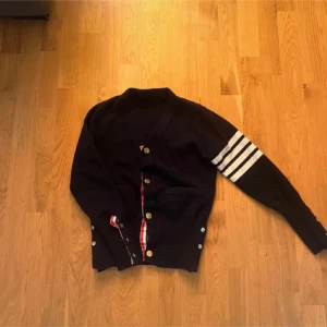 Svart kofta från Thom Browne med ränder -  passa någon runt 150-155 Tagen är inte kvar i tröjan