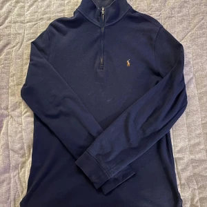 Polo Ralph Lauren Zip  - Mörkblå långärmad tröja från Polo Ralph Lauren med klassisk broderad logga på bröstet. Tröjan har en half zip-dragkedja vid halsen och är gjord i mjuk bomull.  Barnstorlek XL vilket ungefär motsvarar S. Lite smutsig på bilderna, tvättas såklart innan köp. Priset kan diskuteras och kan skicka flera bilder vid behov! Byten kan även var aktuellt.