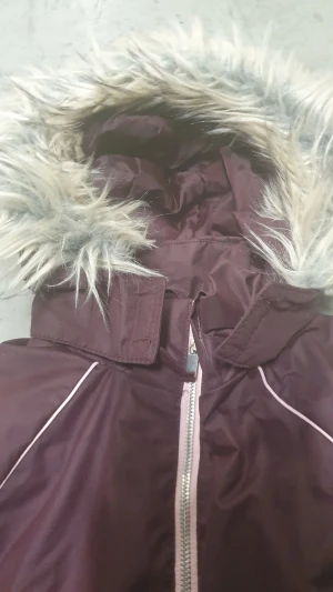 Vinterjacka - Snygg lila vinterjacka från H&M med fluffig fuskpäls på huvan och coolt 'Support Your Local Girl Crew'-märke på ärmen. Jackan har dragkedja framtill och praktiska fickor med dragkedja. Perfekt för kalla dagar och riktigt trendig look.