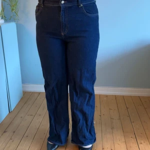 Mörkblå raka jeans från H&M - Snygga mörkblå jeans från H&M i klassisk rak-modell. Jeansen har hög midja och raka ben. Tillverkade i slitstarkt denim med kontrastsömmar. Perfekta för dig som gillar en tidlös look.