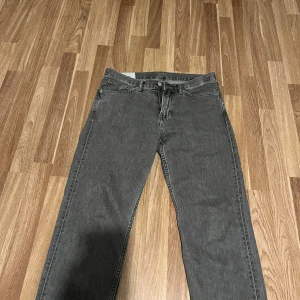 Grå relaxed fit jeans från H&M - Säljer ett par grå jeans från H&M i relaxed fit med raka ben och klassisk femficksdesign. Jeansen har en mörkgrå tvätt och är tillverkade i jeansmaterial med dragkedja och knapp framtill. Perfekt för dig som gillar en loose och chill stil. Fråga gärna om mått och kom med bud! 