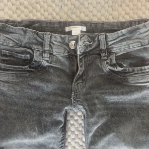 Grå lågmidjade jeans från ginatricot - Grå lågmidjade utsvängda jeans från ginatricot!! Knappt använda och är i mycket bra skick❣️