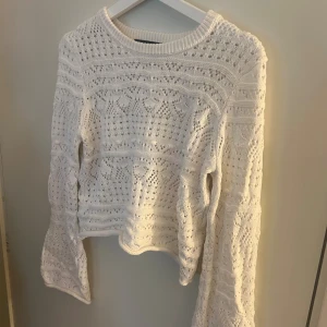 Vit stickad tröja French Connection - Supersöt vit stickad tröja från French Connection i storlek S. Tröjan har ett detaljerat hålmönster, rund hals och långa ärmar. Perfekt för dig som gillar en chill och feminin stil med lite boho-vibe. Passar till jeans eller kjol för en fräsch look.