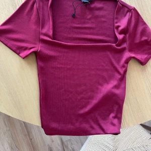 Vinröd topp med fyrkantig ringning Amisu - Säljer en vinröd crop topp (går lite över naveln) från Amisu/ New Yorker i storlek S. Toppen är använd men har bra skick.