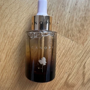 Canopy Brightening Serum 30ml - Canopy Brightening Brilliance Serum i en lyxig glasflaska med guldig och svart ombre-effekt. Kommer med pipett för enkel applicering. Innehåller aktiva ingredienser som niacinamid och kakaduplommonextrakt för en strålande hudton.